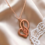 Rose gold plated Arabic calligraphy mother necklace with a decorative heart pendant displayed on soft satin from KIRO UK