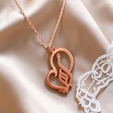 Rose gold plated Arabic calligraphy mother necklace with a decorative heart pendant displayed on soft satin from KIRO UK