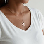 KIRO UK gold plated Arabic calligraphy necklace featuring a My Mother pendant in a decorative heart shape worn on a woman in a white top