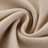 Close up of beige cotton fabric with a soft textured weave and flowing folds from kiro Clothing collection