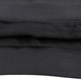 Close up of black cotton hoodie fabric showing ribbed hem and layered seam detail from KIRO Clothing