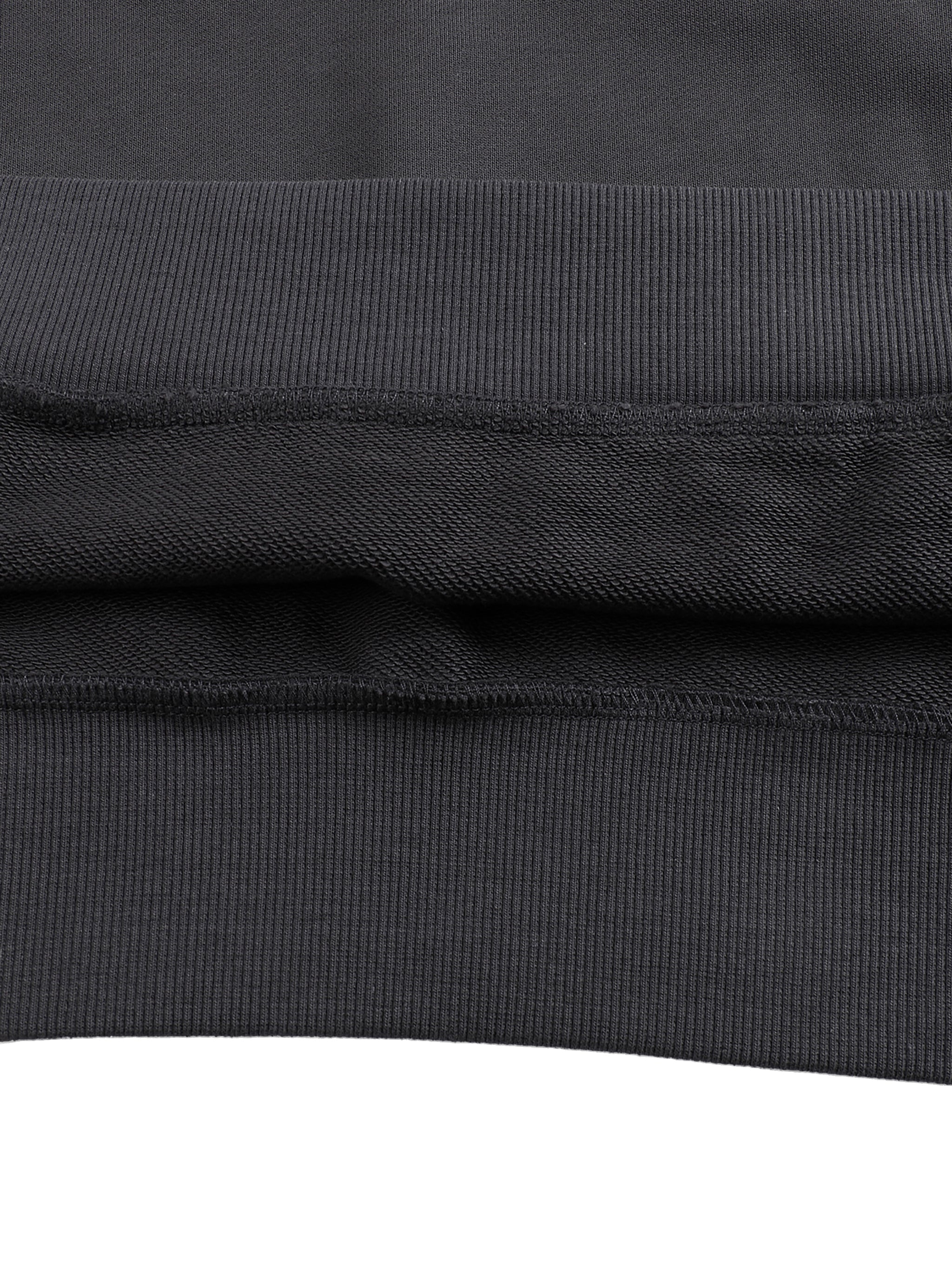 Close up of black cotton hoodie fabric showing ribbed hem and layered seam detail from KIRO Clothing