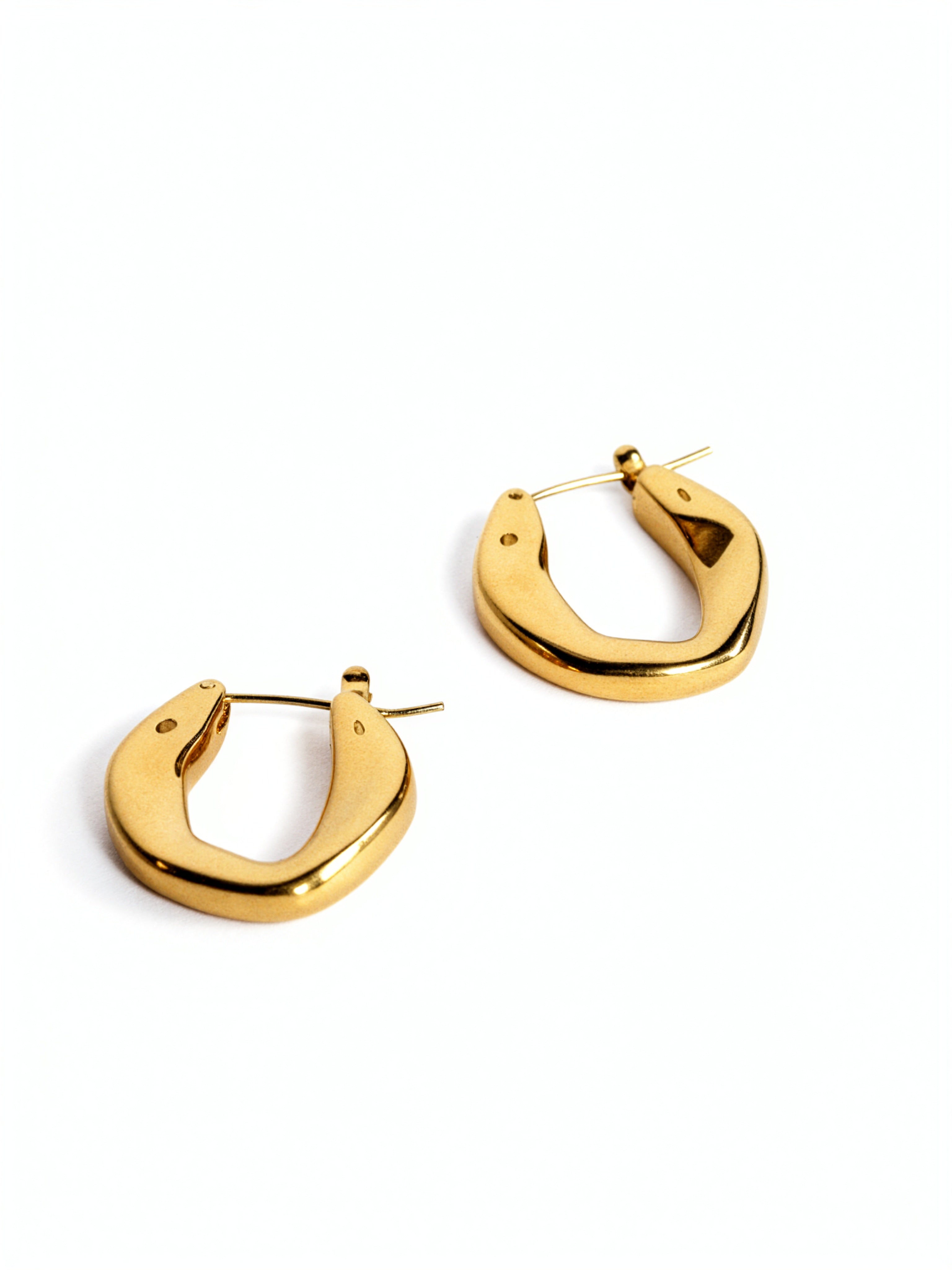 Pair of chunky oval 18K gold plated hoop earrings by KIRO UK on a white background with a smooth polished finish and secure hinged closures
