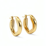 Pair of 18K gold plated oval hoop earrings from KIRO UK with a smooth chunky statement design on a white background