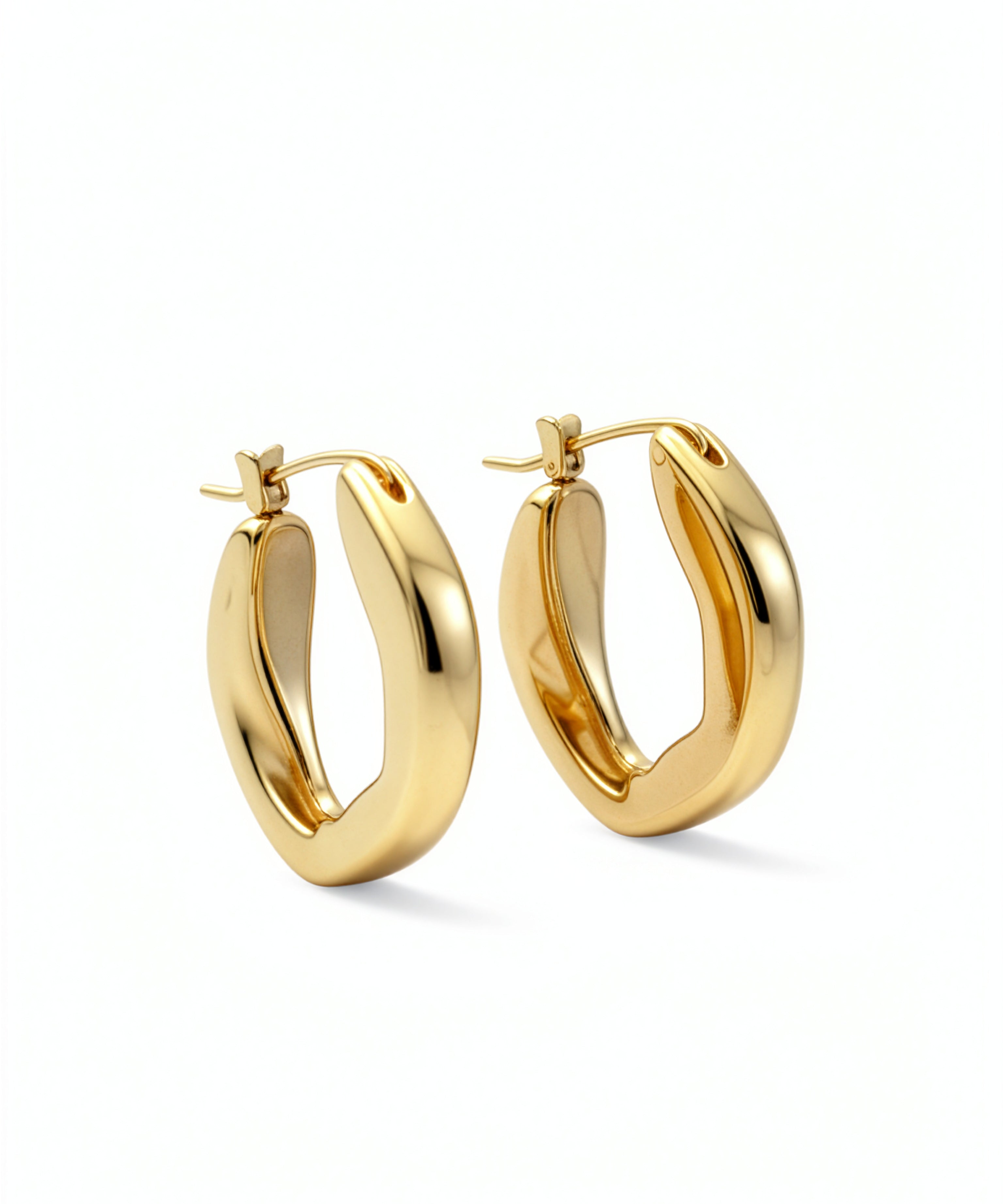 Pair of 18K gold plated oval hoop earrings from KIRO UK with a smooth chunky statement design on a white background