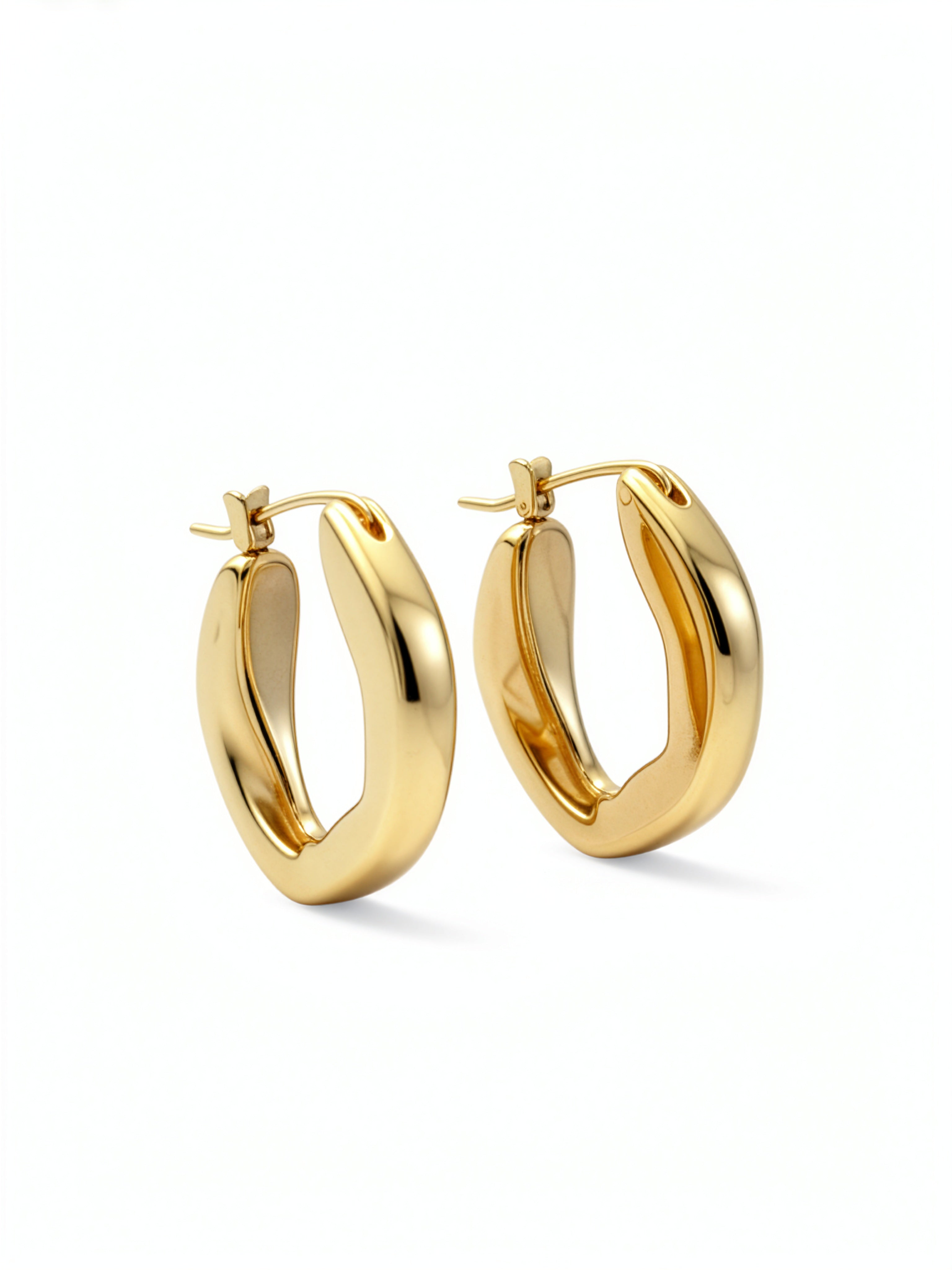 Pair of 18K gold plated oval hoop earrings from KIRO UK with a smooth chunky statement design on a white background