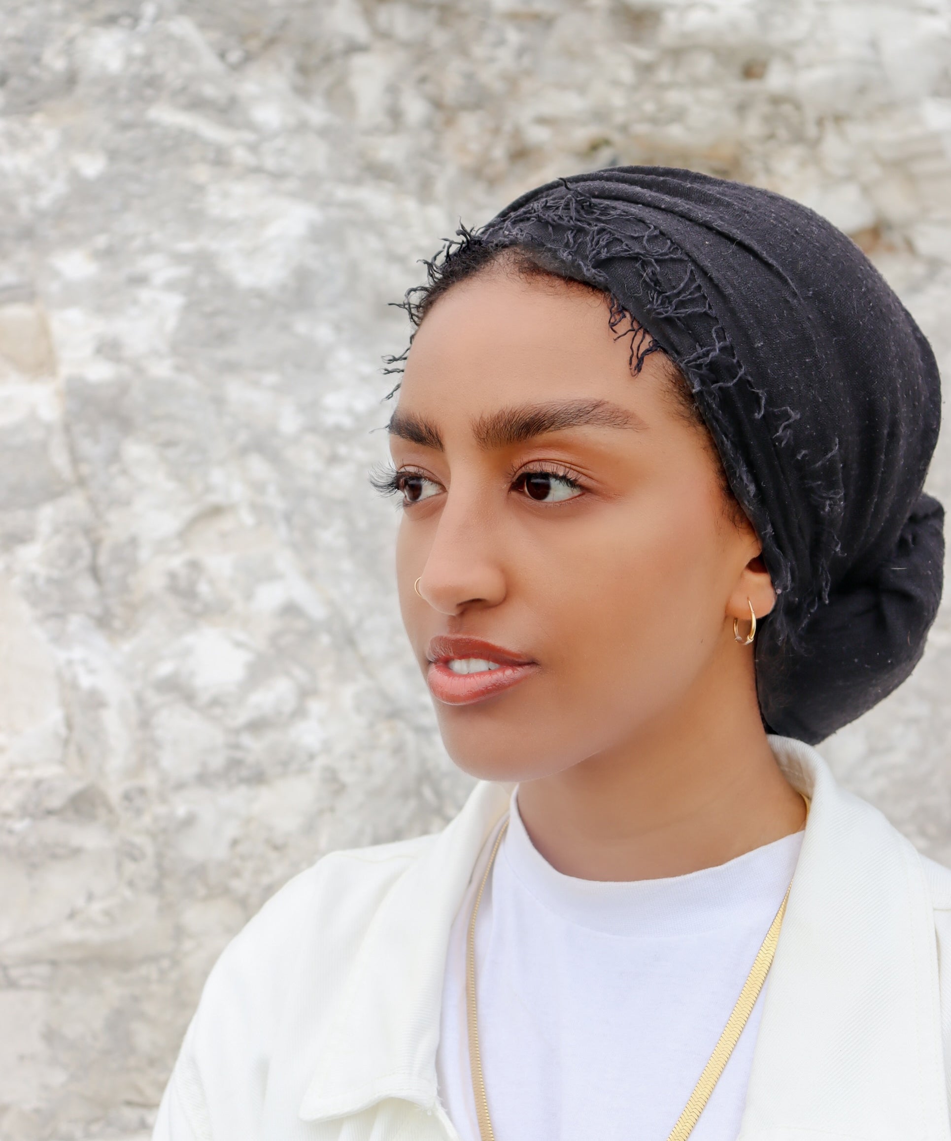 Woman wearing a gold plated statement necklace from KIRO UK Egyptian Collection with a smooth collar design and polished finish layered over a white top