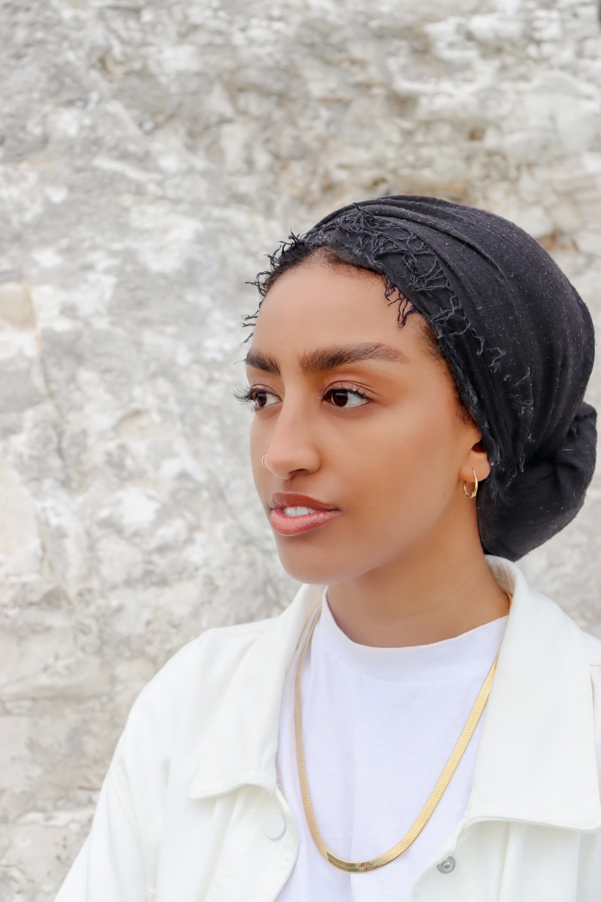 Woman wearing a gold plated statement necklace from KIRO UK Egyptian Collection with a smooth collar design and polished finish layered over a white top