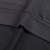 Close-up of black cotton hoodie fabric with a ribbed hem detail from KIRO Clothing