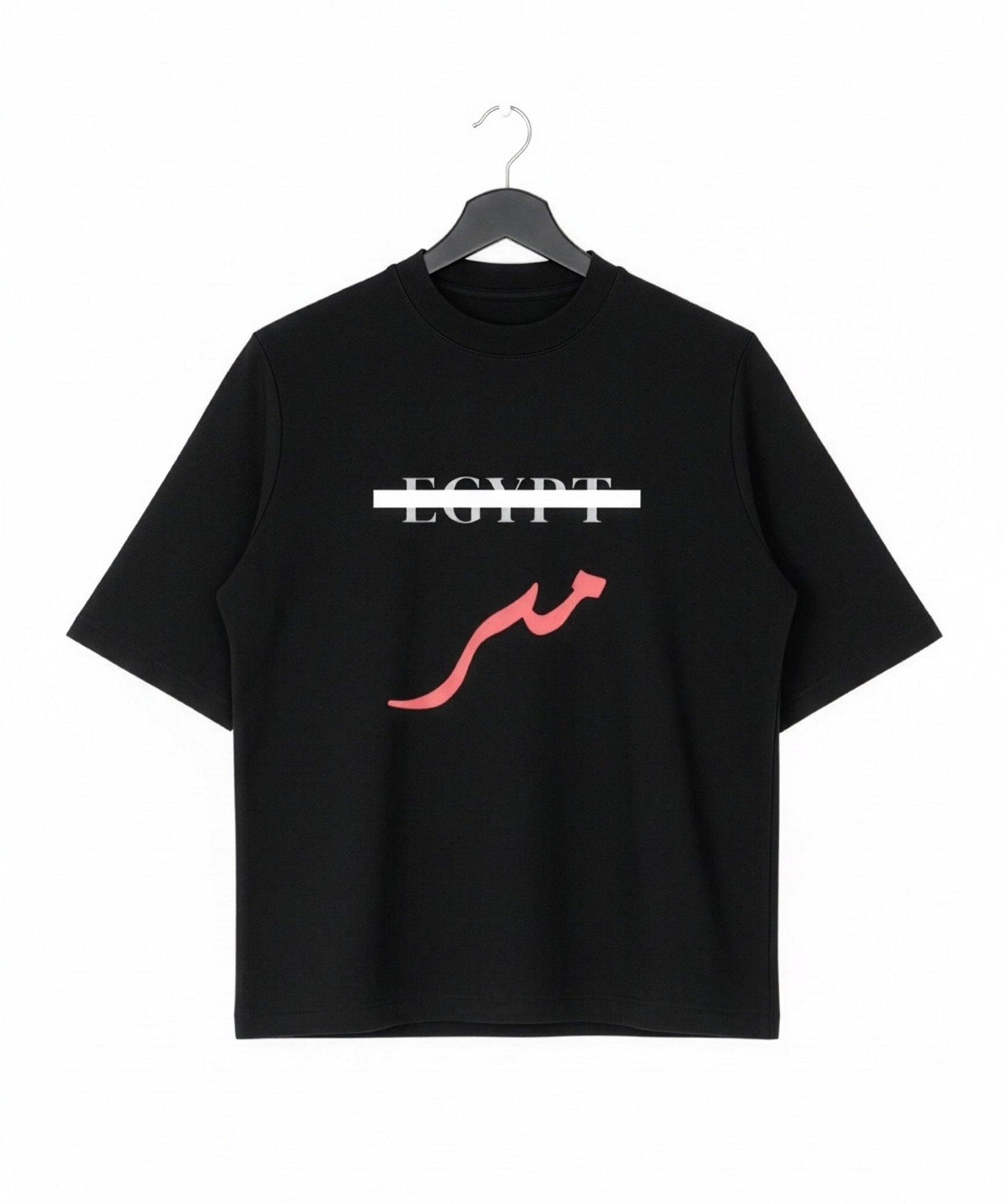 Black oversized cotton T shirt on a hanger with Egypt crossed out in white and red Arabic Masr lettering below from KIRO Clothing