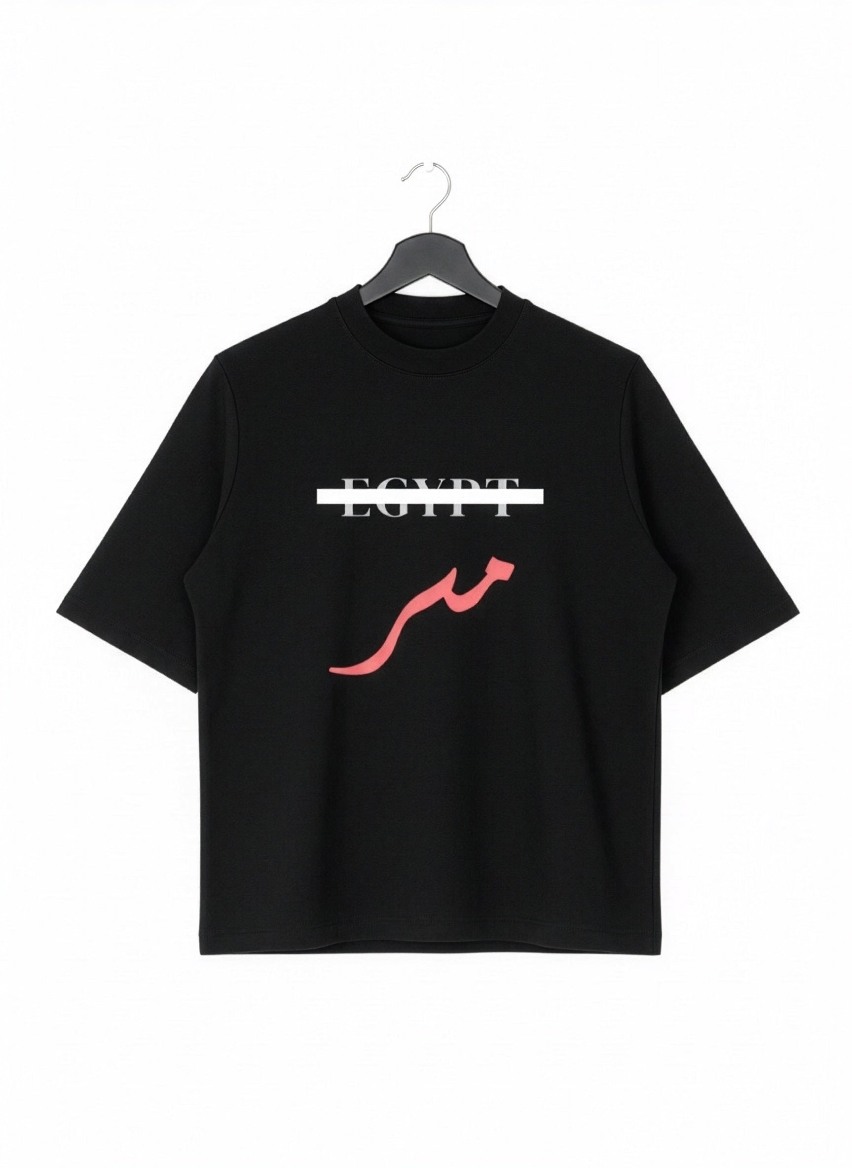 Black oversized cotton T shirt on a hanger with Egypt crossed out in white and red Arabic Masr lettering below from KIRO Clothing