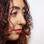 Close-up of a woman wearing a gold serpent faux nose ring, shown on the side of her nose. KIRO UK Nose Ring, Faux nose rings collection
