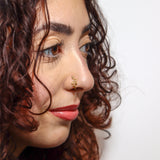 Close-up of a woman wearing a gold serpent faux nose ring, shown on the side of her nose. KIRO UK Nose Ring, Faux nose rings collection