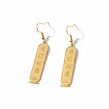 KIRO gold plated stainless steel drop earrings featuring engraved Egyptian hieroglyphs in an oval cartouche design.