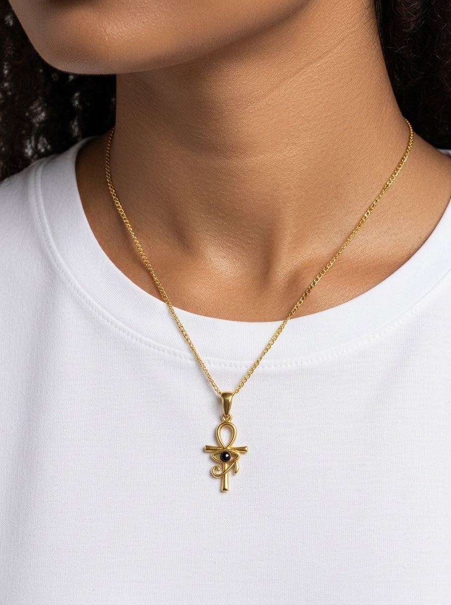 KIRO gold Ankh Horus fusion pendant necklace with a central black gemstone worn on a delicate chain