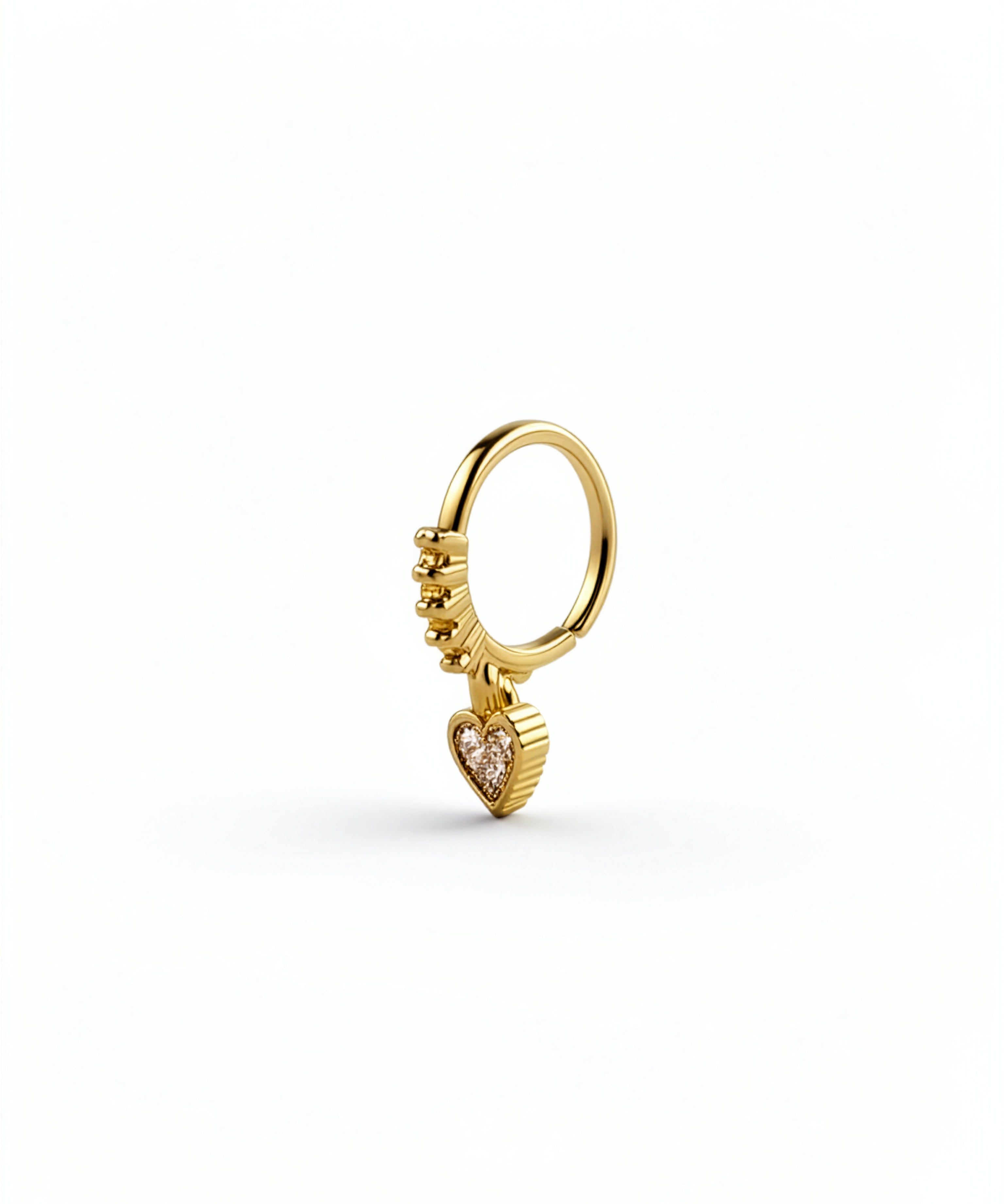 Gold KIRO UK nose ring with a dangling heart shaped cubic zirconia charm on a white background