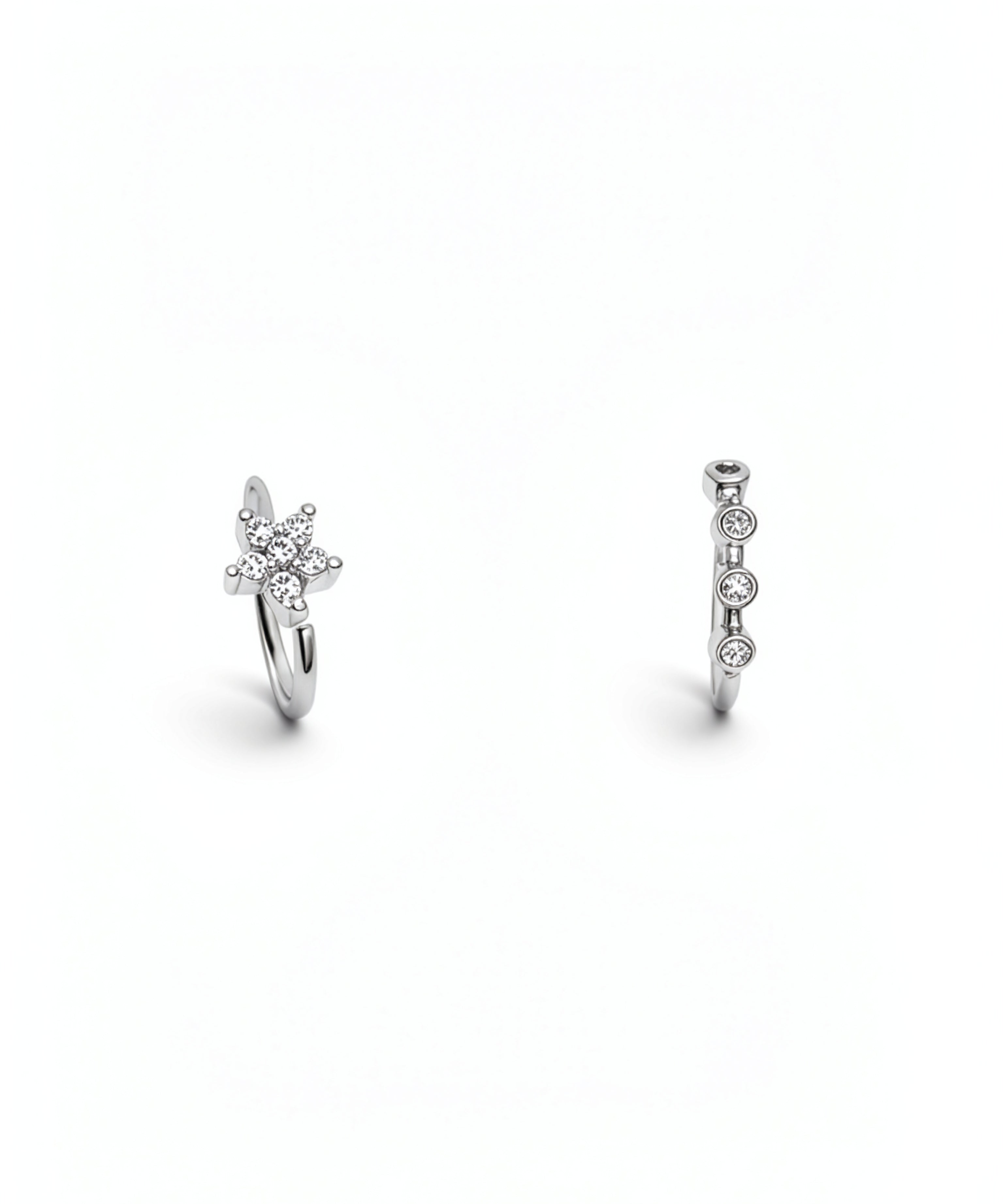 Two sterling silver nose rings with sparkling cubic zirconia details, including a floral cluster design and a vertical row of round stones on a white background