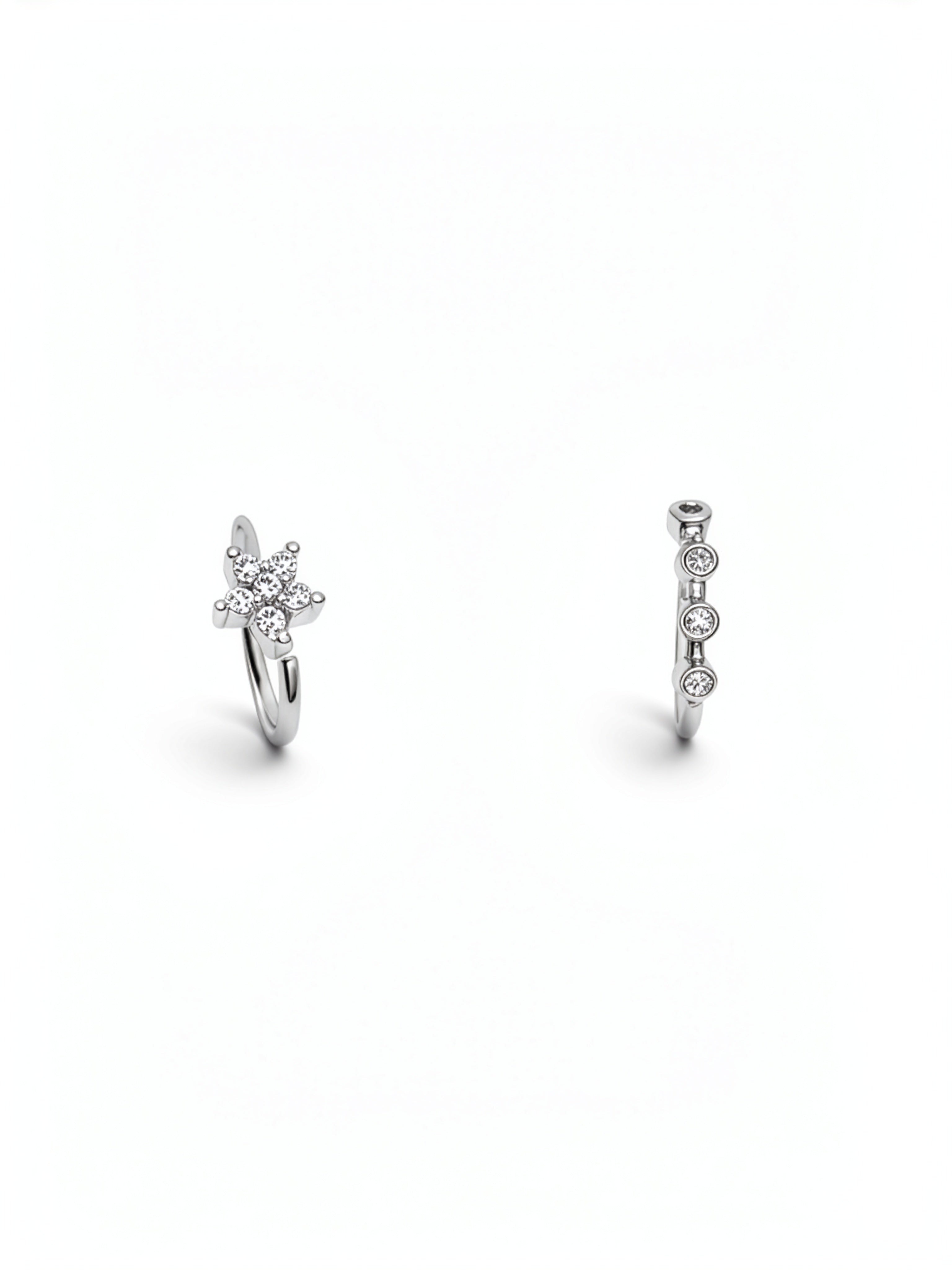 Two sterling silver nose rings with sparkling cubic zirconia details, including a floral cluster design and a vertical row of round stones on a white background