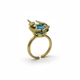 KIRO Amarna ring with a blue-green oval cubic zirconia gemstone set in 18K gold plated metal with unique claw-like details. Resizeable.
