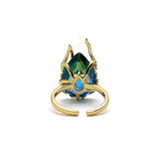 KIRO Amarna ring with a large, faceted blue-green cubic zirconia gemstone set in 18K gold plated metal. Resizeable.