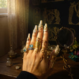 KIRO Amarna Ring with blue-green cubic zirconia on 18K gold plated band, resizeable. Stacked with other gold rings.