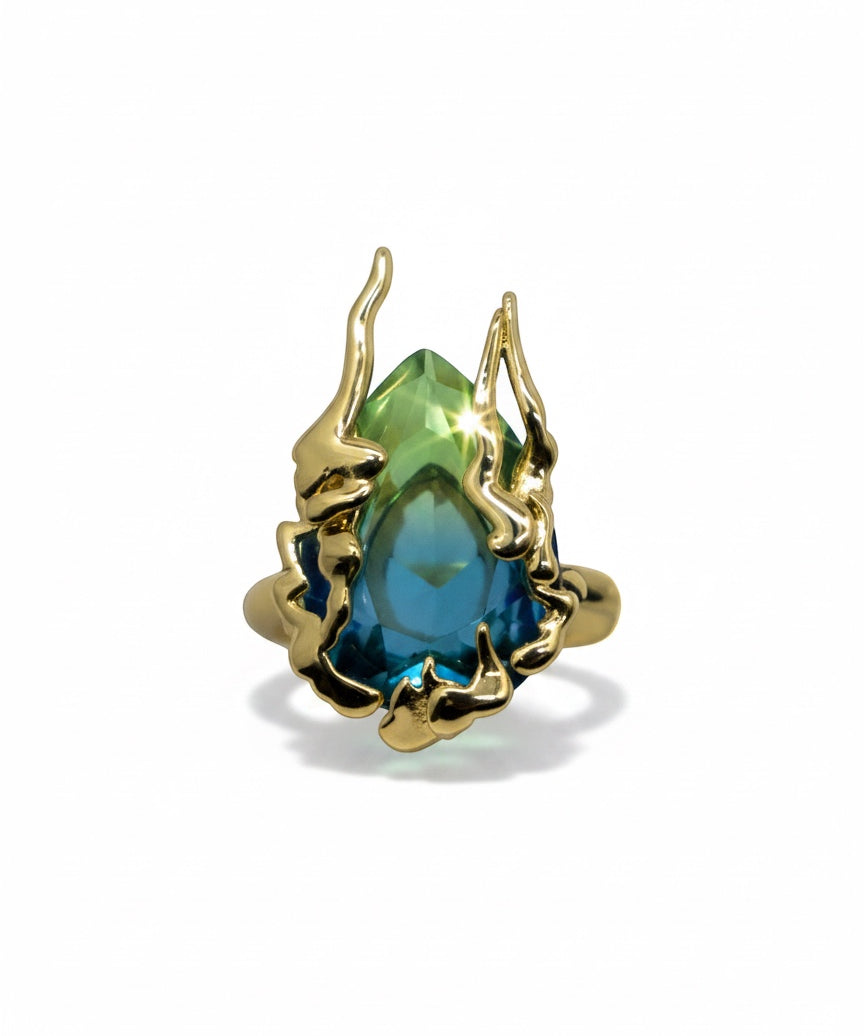 KIRO Amarna ring with a large, faceted blue-green cubic zirconia gemstone set in 18K gold plated metal. Resizeable.