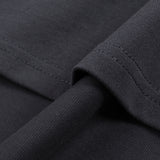 Black cotton T shirt fabric close up showing a fine weave and neatly stitched hem detail