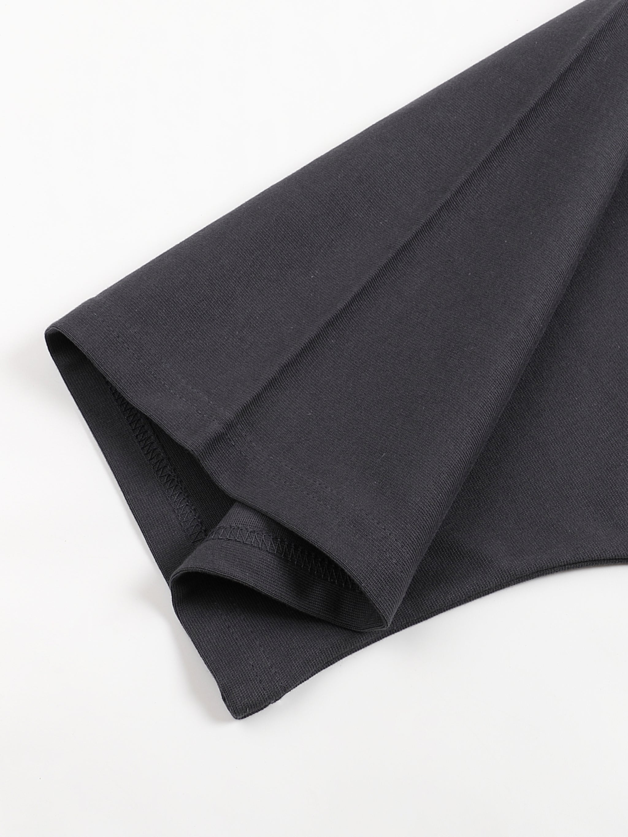 Close up of black cotton t shirt fabric and folded hem from KIRO in Clothing