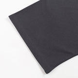 Close up of black cotton fabric from a KIRO Egyptian collage T shirt showing a smooth knit texture and clean hem edge