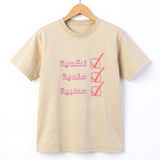 Beige unisex T shirt on a wooden hanger with a pink Arabic checklist graphic, from Kiro Clothing