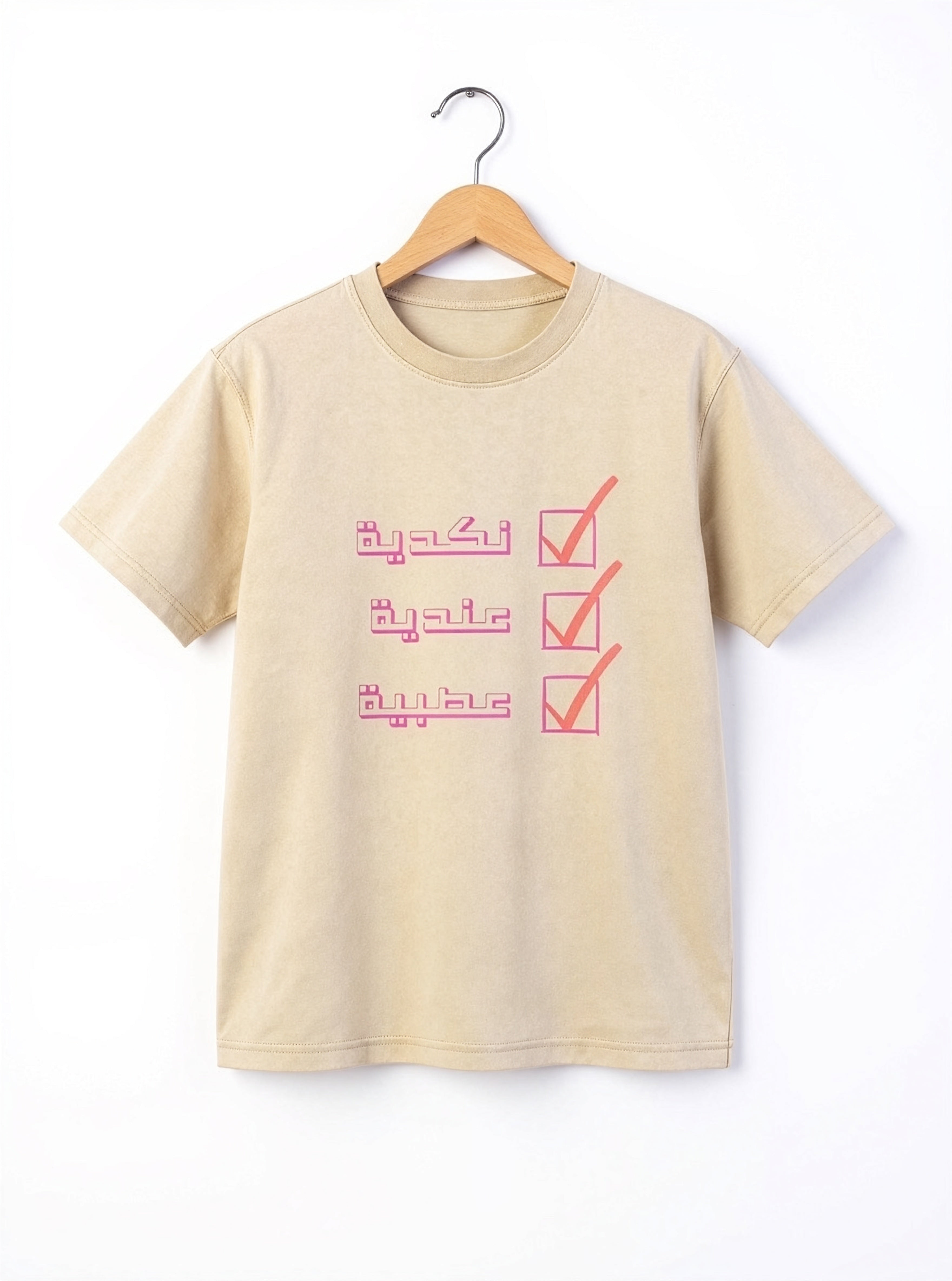 Beige unisex T shirt on a wooden hanger with a pink Arabic checklist graphic, from Kiro Clothing
