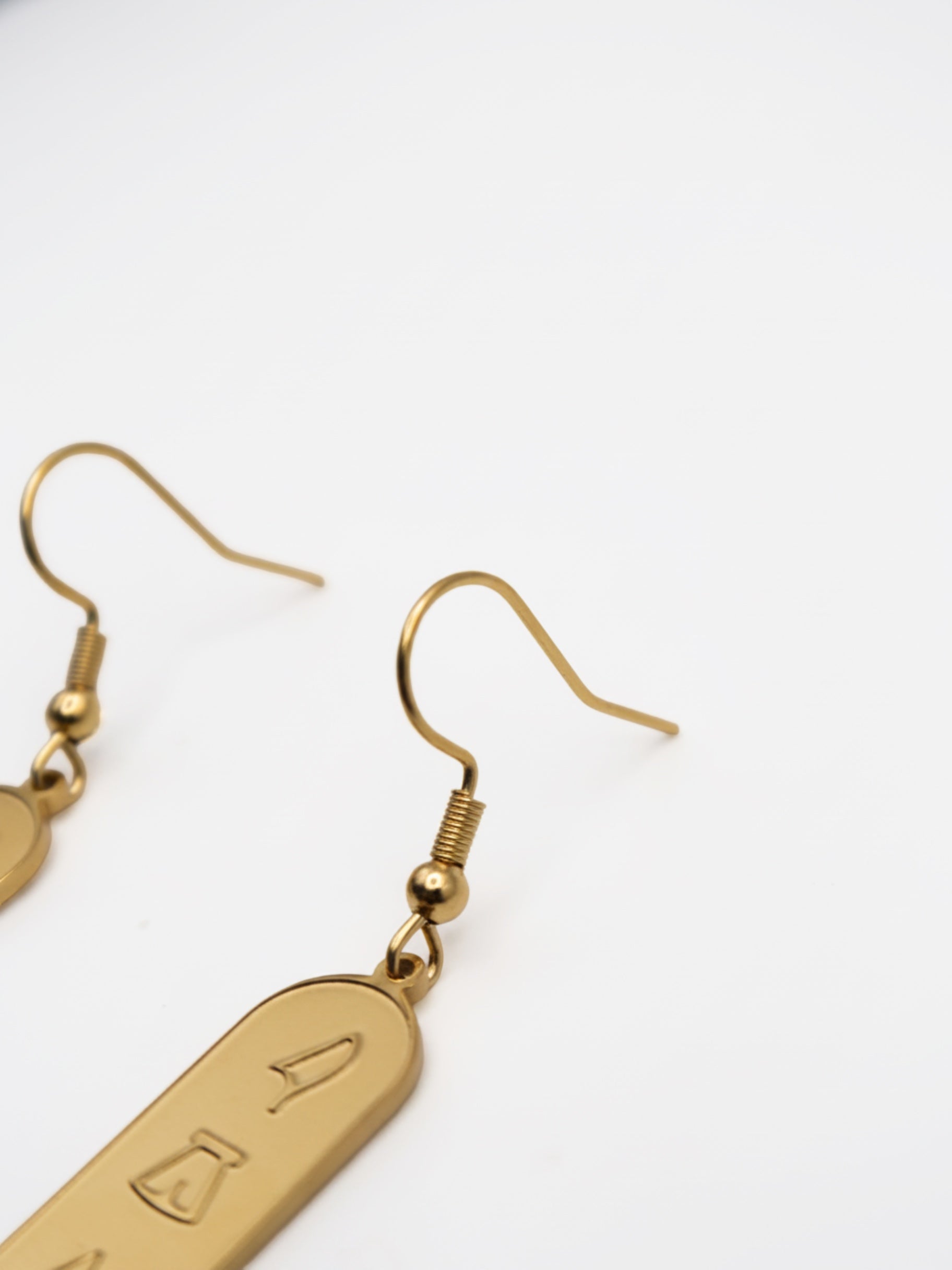 KIRO 18K gold plated stainless steel drop earrings featuring engraved Egyptian hieroglyph cartouche pendants.