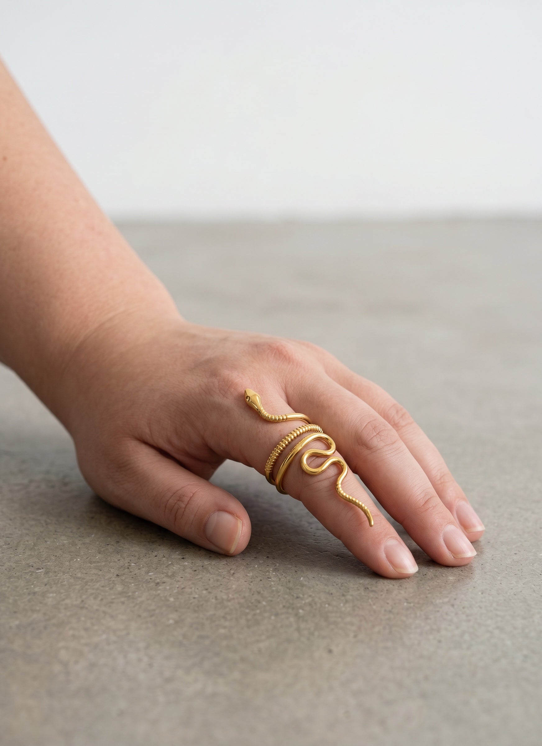 KIRO gold plated snake ring with intricate detailing, wraps around finger. Resizable statement jewelry.