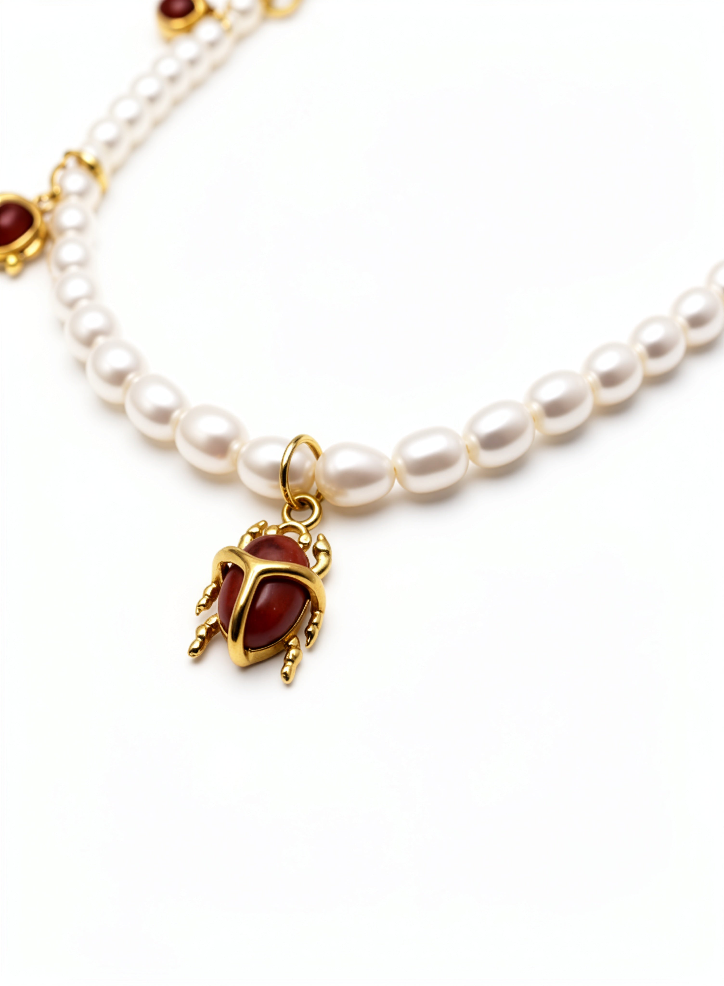 KIRO Scarab Pearl Necklace featuring ivory freshwater pearls and five gold-plated scarab charms with carnelian stones.
