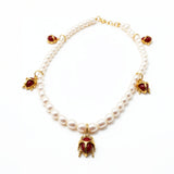 KIRO Scarab Pearl Necklace featuring ivory freshwater pearls and five 18k gold-plated scarab charms with carnelian stones.