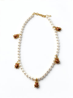 KIRO Scarab Pearl Necklace featuring ivory freshwater pearls and five gold-plated scarab charms with carnelian stones.