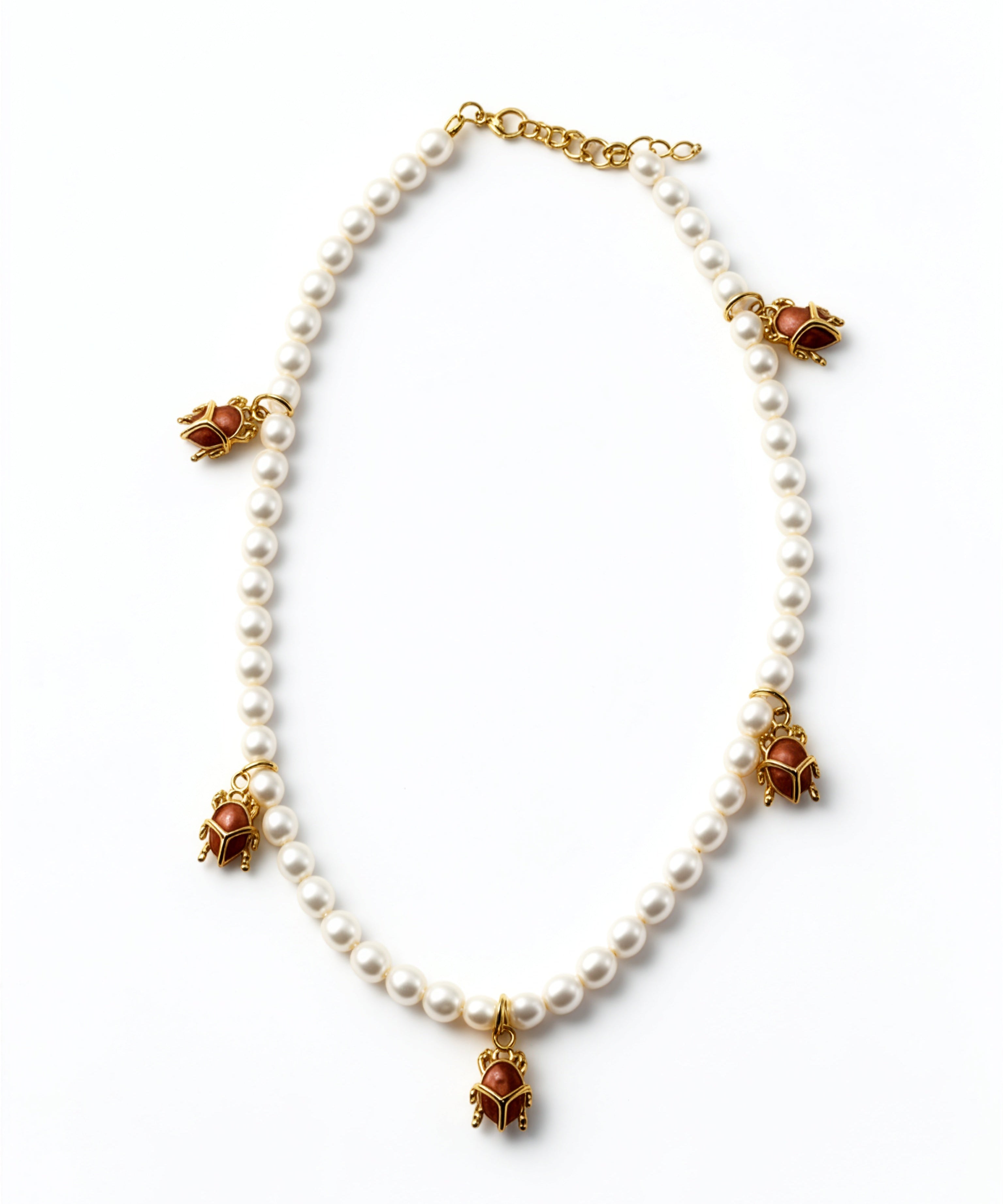 KIRO Scarab Pearl Necklace featuring ivory freshwater pearls and five gold-plated scarab charms with carnelian stones.