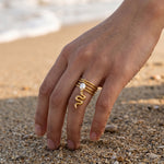KIRO gold plated stackable ring with a dangling serpent charm and pearl accent. Resizeable.