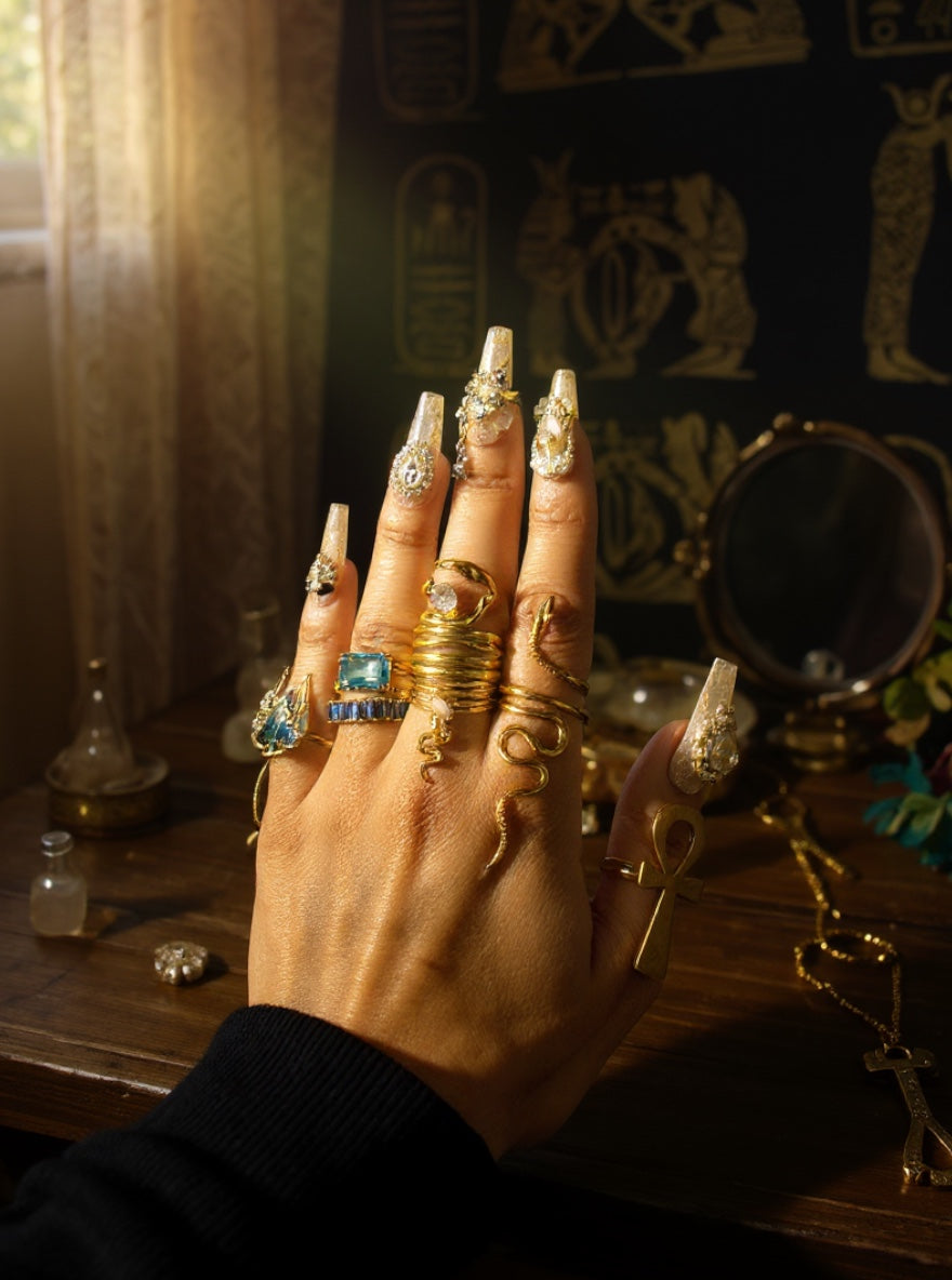 KIRO gold plated stackable rings, including a coiled serpent design and a ring with a clear gem.