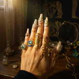 KIRO gold plated stackable rings, including a coiled serpent design and a ring with a clear gem.