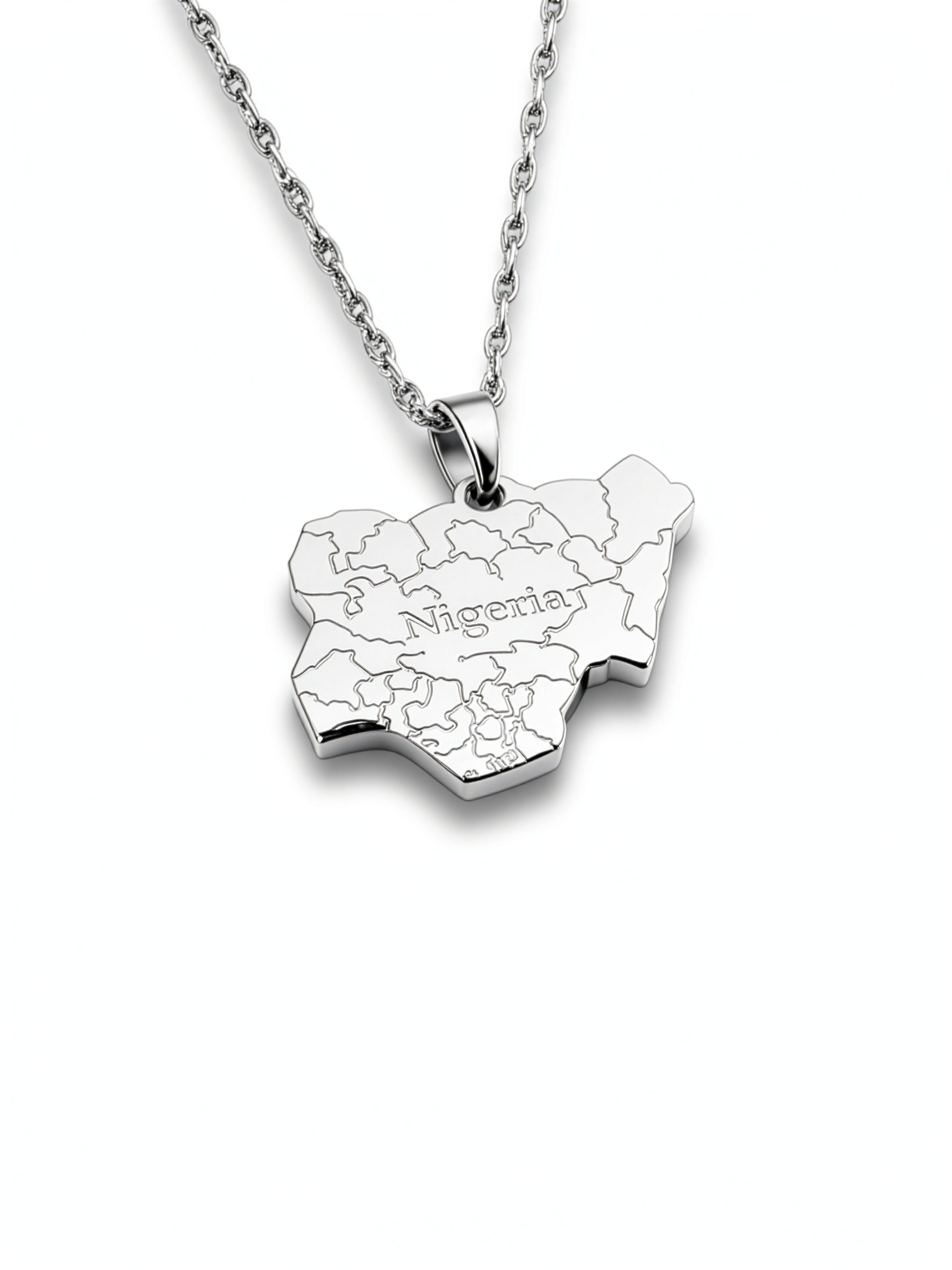 silver necklace of the map of Nigeria. "Nigeria" is written in the middle with all the cities engraved. the pendant hangs on a water wave chain.