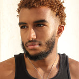 A man wearing a silver plated Nubia map necklace with a small engraved map pendant celebrating Nubian heritage by KIRO UK