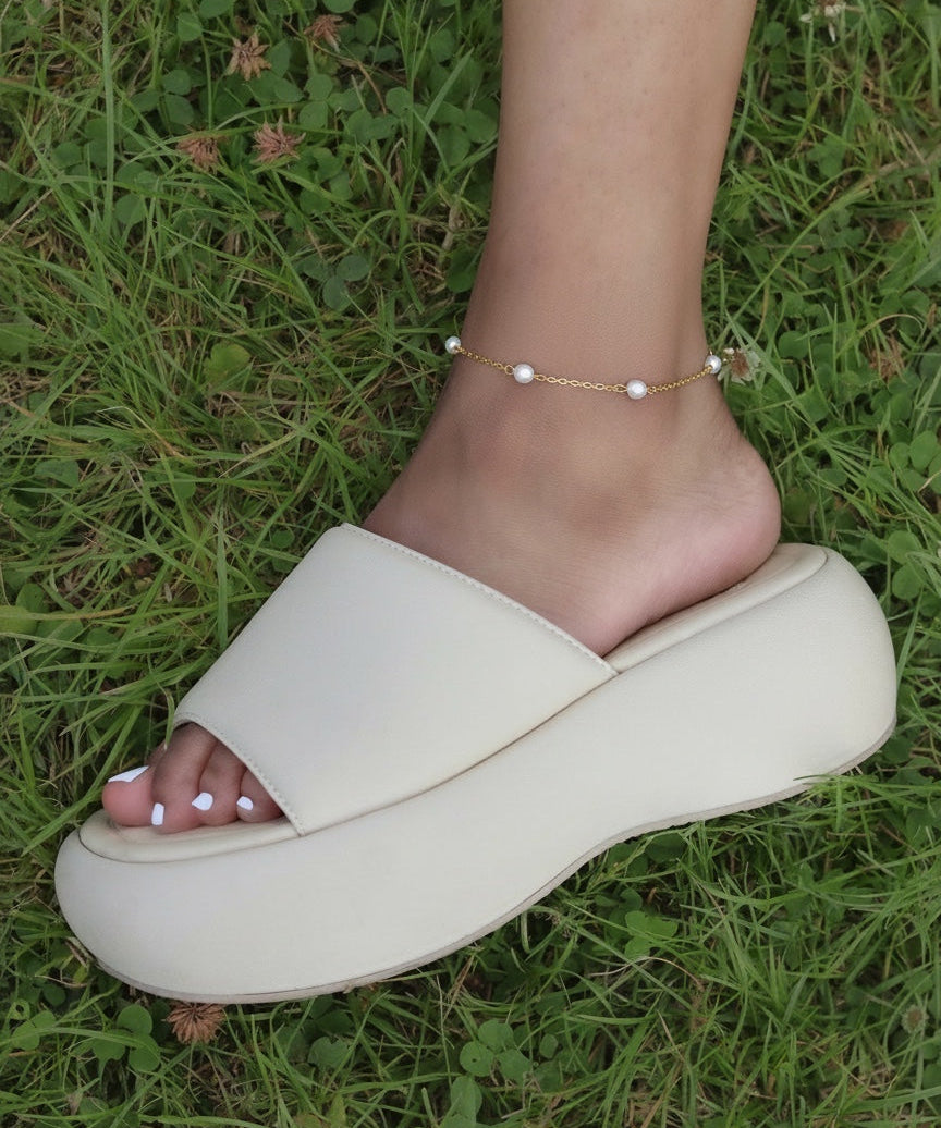 KIRO Lulu gold chain anklet with delicate freshwater pearls worn on an ankle above a cream platform slide sandal
